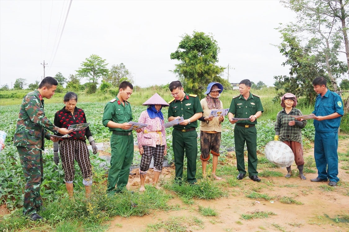 Cán bộ thuộc Đề án 1371 phát tờ rơi tuyên truyền đến người dân