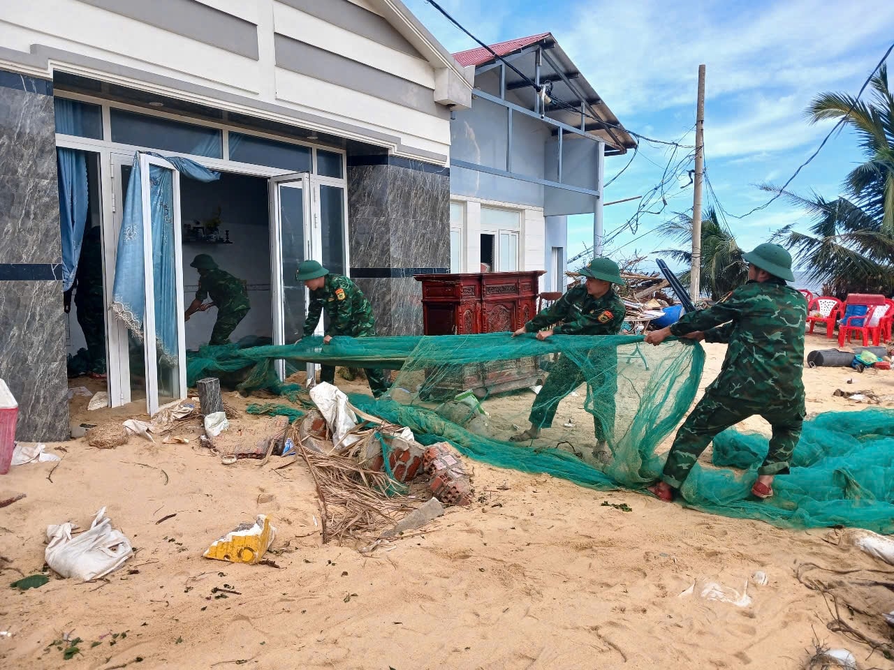 Cán bộ, chiến sĩ Đồn Biên phòng Cát Khánh, xã Đề Gi giúp dân dọn dẹp nhà cửa sau cơn bão số 13 Cán bộ, chiến sĩ Đồn Biên phòng Cát Khánh, xã Đề Gi giúp dân dọn dẹp nhà cửa sau cơn bão số 13