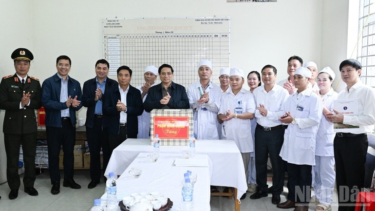 Thủ tướng Phạm Minh Chính tặng quà động viên cán bộ, nhân viên Trạm Y tế xã Yên Khương. (Ảnh: TRẦN HẢI)