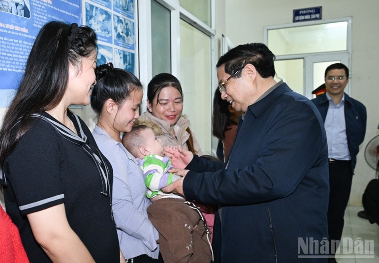 Thủ tướng Phạm Minh Chính ân cần thăm hỏi bà con nhân dân đến khám bệnh tại Trạm Y tế xã Yên Khương. (Ảnh: TRẦN HẢI)