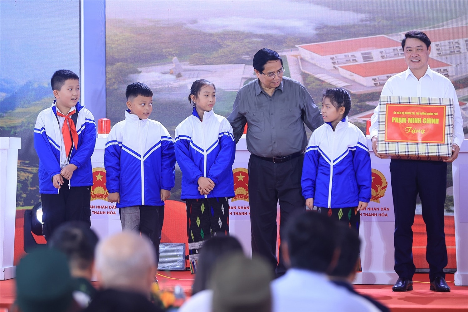 Thủ tướng Phạm Minh Chính trao quà tặng cùng áo ấm cho các em học sinh tại lễ khởi công. Ảnh: VGP