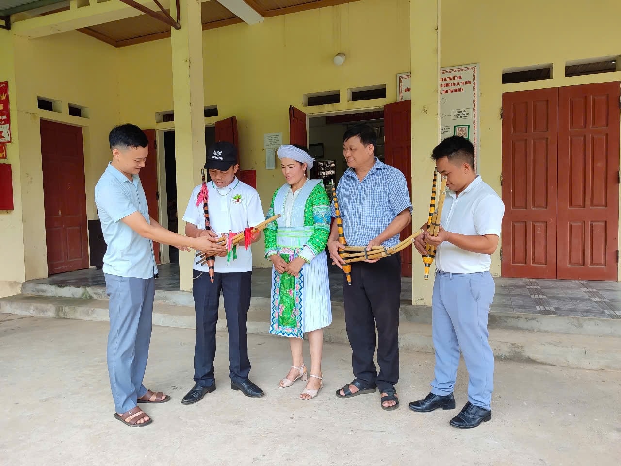 Nghệ nhân Hoàng Văn Dùng (đứng thứ 2 từ trái sang), gắn bó cả đời với tiếng khèn Mông, hướng dẫn kỹ năng thổi khèn, cách múa khèn và hát dân ca (Ảnh: Thảo Khánh)