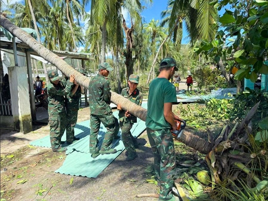 Lực lượng quân sự hỗ trợ dọn dẹp cây cối bị ngã đổ đảm bảo lưu thông sau bão số 13. (Ảnh: P.H)