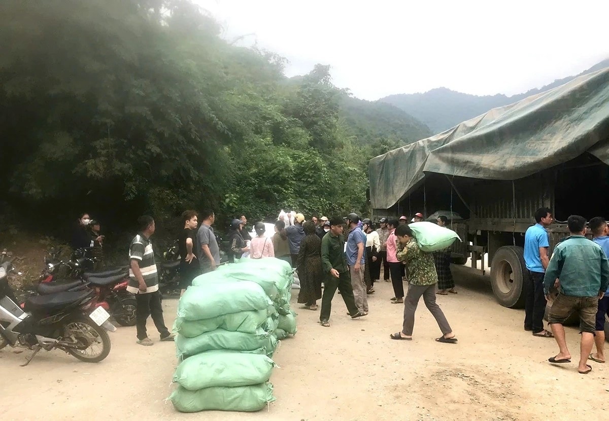 Người dân vùng cao Mường Lát vận chuyển gạo về bản trong niềm vui, phấn khởi. (ảnh Hồ Thủy)