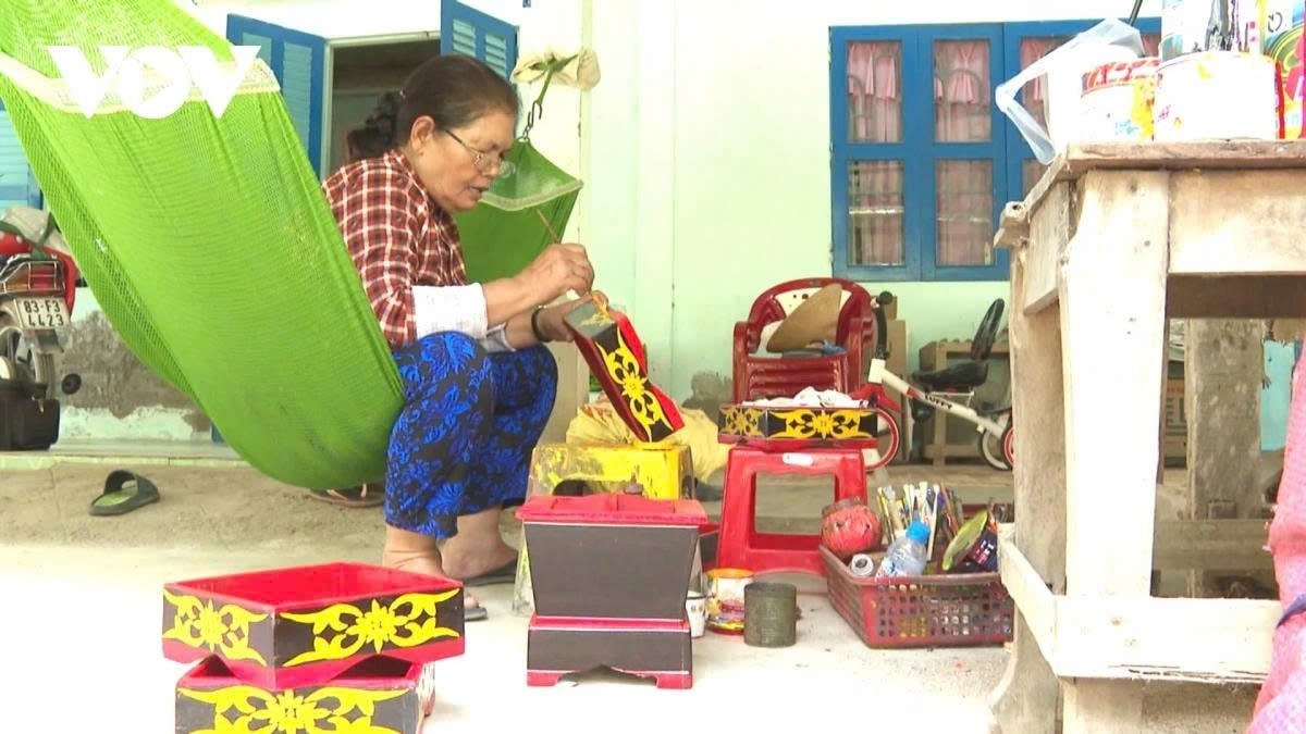 Bà Triệu Thị Vui đang vẽ hoa văn cho khay trầu cau