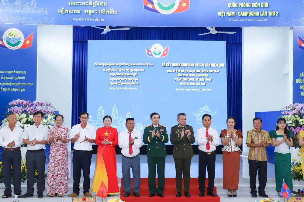 Bộ trưởng Bộ Quốc phòng hai nước chụp ảnh lưu niệm cùng nhân dân 2 ấp vừa ký kết nghĩa 