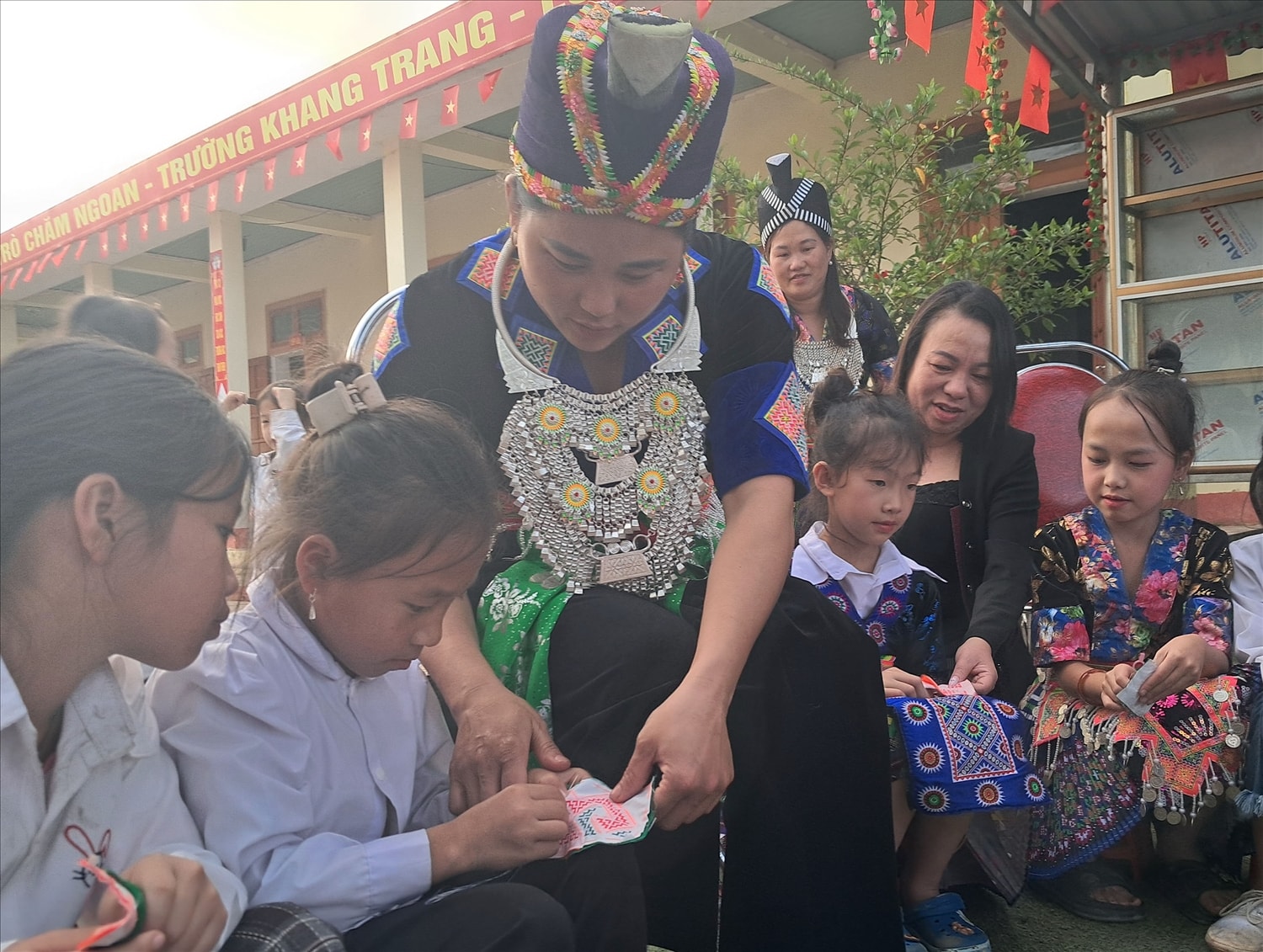 Các em gái người Mông được nghệ nhân dạy cách thêu thùa hoa văn trên váy, áo truyền thống.