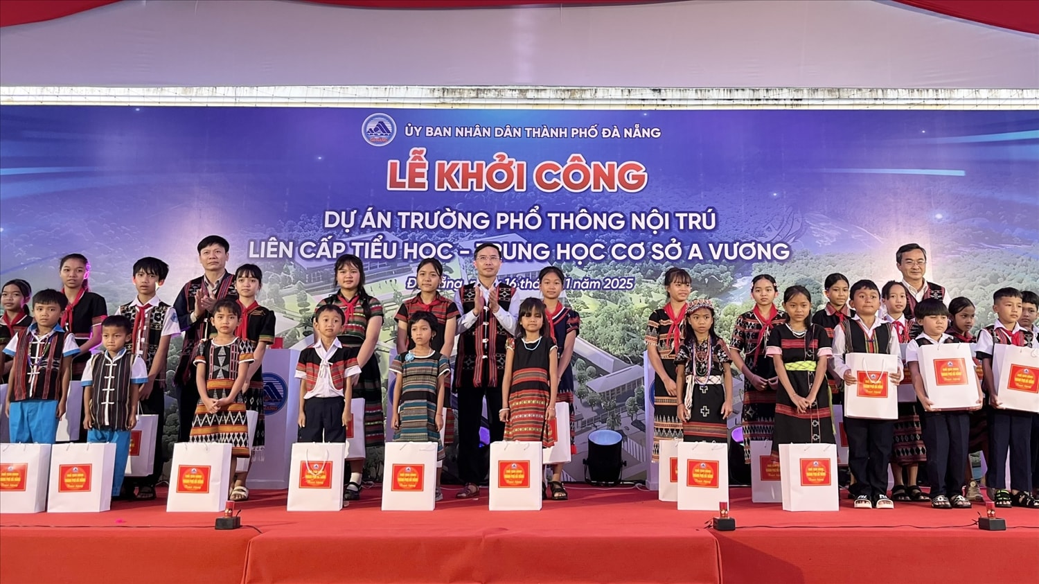 Chủ tịch UBND TP Đà Nẵng Phạm Đức Ấn (đứng giữa) tặng quà cho các em học sinh tại lễ khởi công  dự án Trường phổ thông nội trú liên cấp Tiểu học - Trung học cơ sở xã A Vương. (Ảnh: Cổng TT Đà Nẵng)