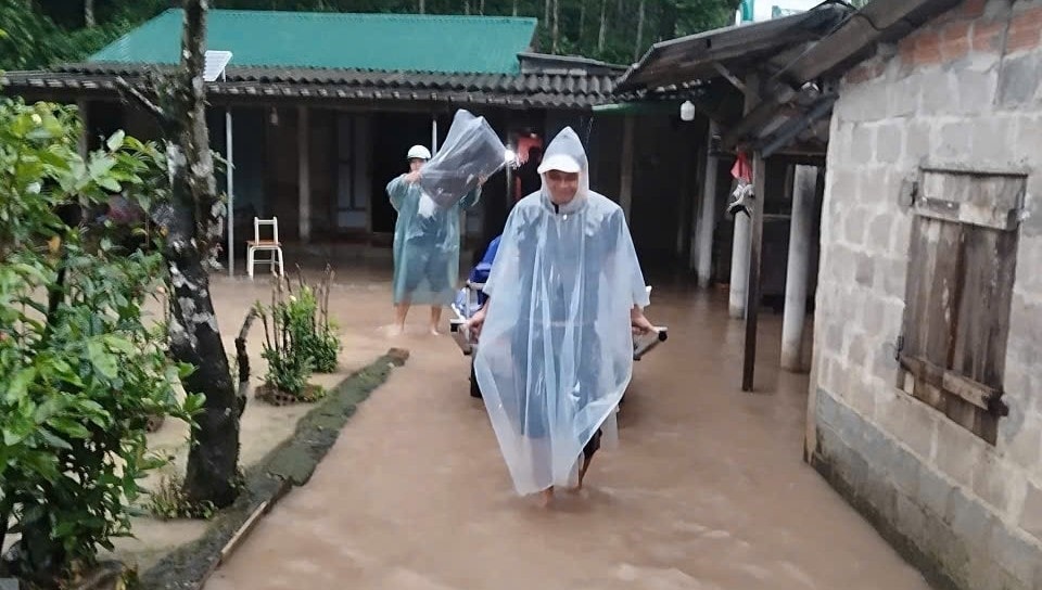 Chính quyền địa phương và người dân ở xã Ba Long hộ trợ bà con vùng trũng di dời người và tài sản