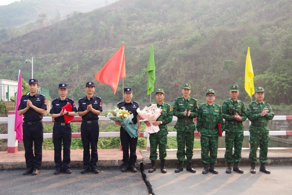 Đội tuần tra BĐBP Lai Châu (Bộ Tư lệnh BĐBP, Việt Nam) và Chi đội Quản lý biên giới Hồng Hà, Trạm Kiểm tra Biên phòng xuất, nhập cảnh Kim Thủy Hà (Trung Quốc) tặng hoa và chụp ảnh lưu niệm tại vạch phân định cầu hữu nghị biên giới Việt Trung. Ảnh: Văn Hợi