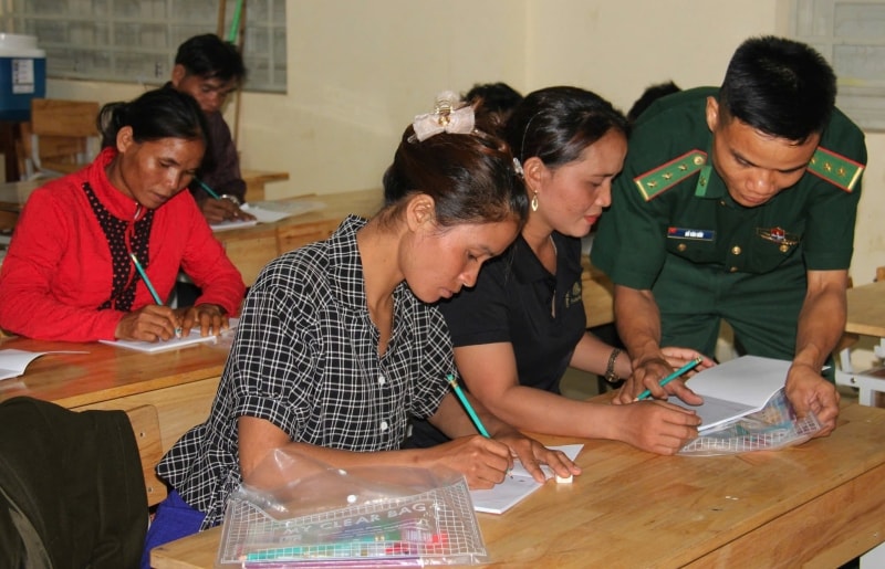 Đại uý Hồ Văn Hữu dạy chữ cho chị em phụ nữ DTTS nơi đơn vị đứng chân (Ảnh MH).