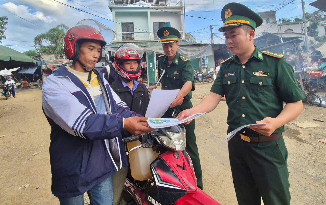 Cán bộ Biên phòng phát tờ rơi tuyên truyền pháp luật cho Nhân dân vùng biên giới.