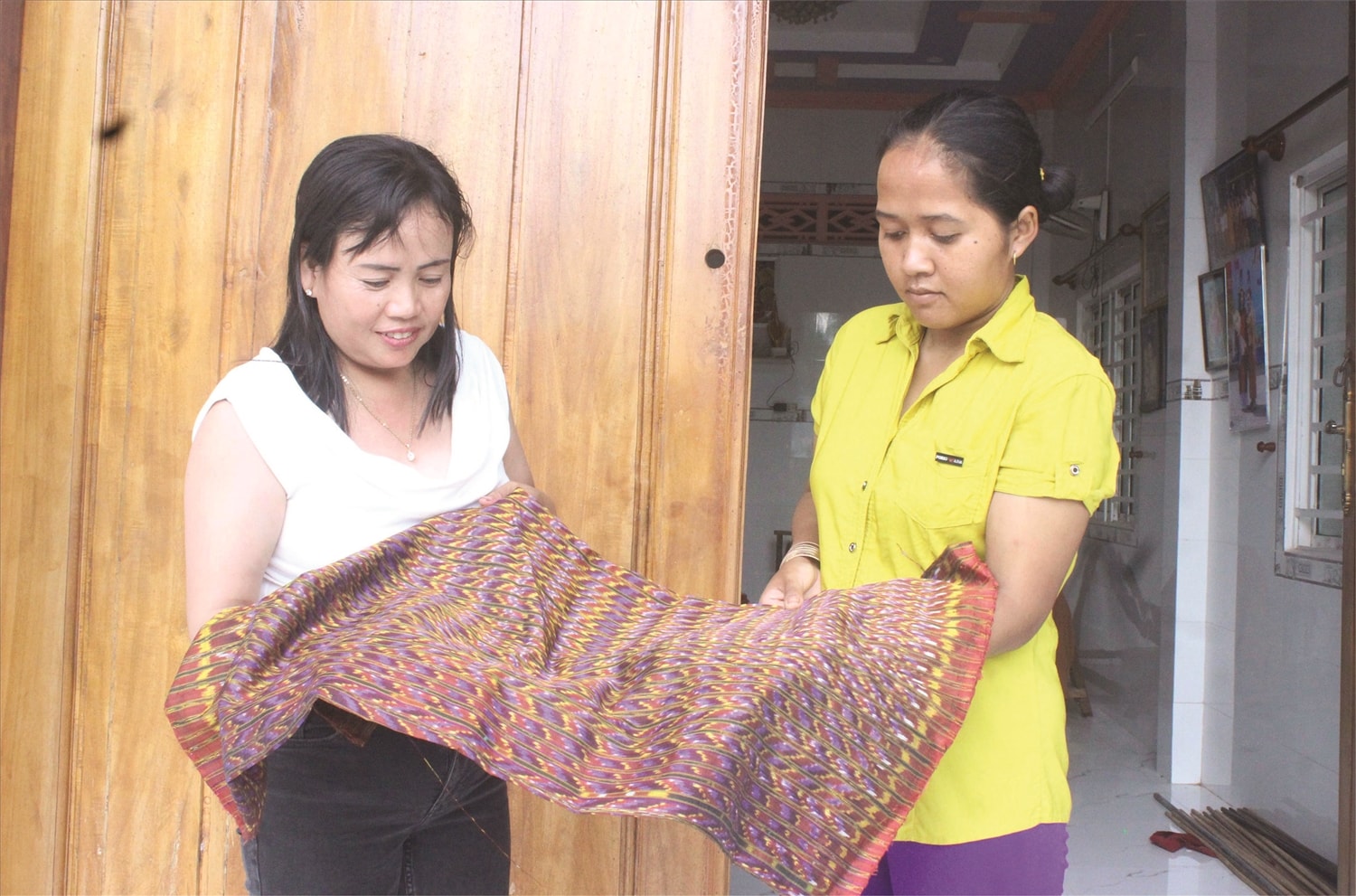 Chị Neáng Chanh Ty (bên trái) tự hào chia sẻ  về các sản phẩm thổ cẩm của làng nghề
