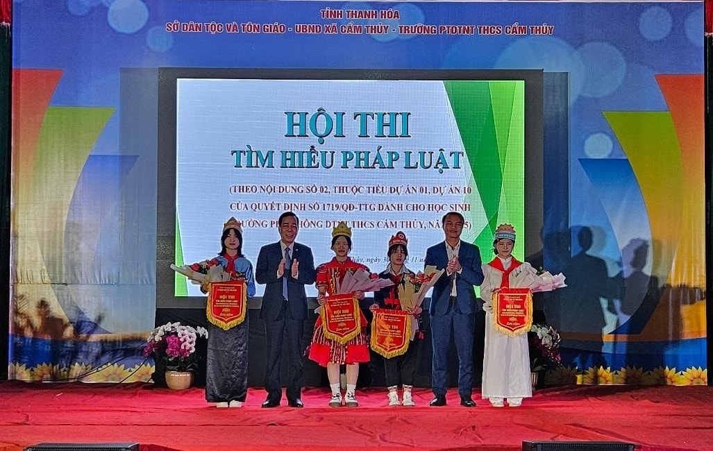 Đại diện lãnh đạo Sở Dân tộc và Tôn giáo tỉnh, UBND xã  Cẩm Thủy trao cờ lưu niệm, chúc mừng các đội tham gia hội thi.(ảnh Quỳnh Trâm)