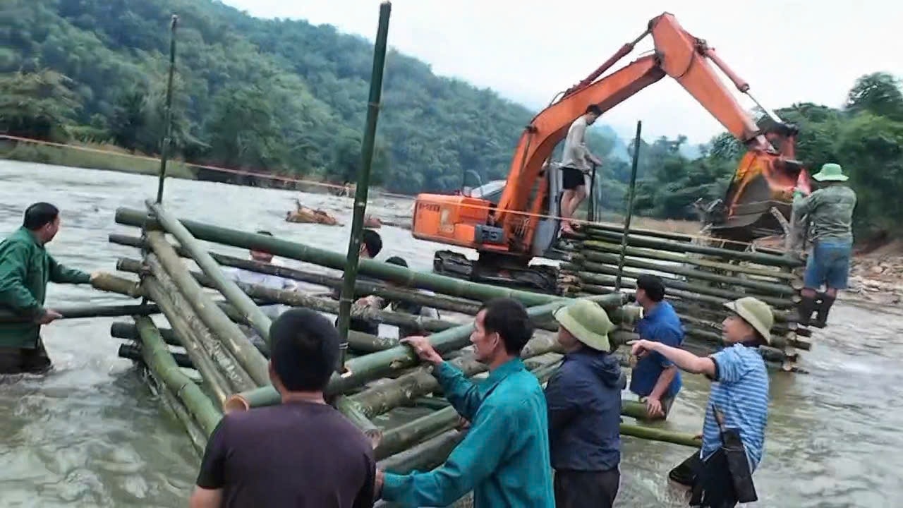Người dân bản Chung Sơn chung tay dựng cầu tạm bắc qua sông Luồng, giúp việc đi lại an toàn hơn.