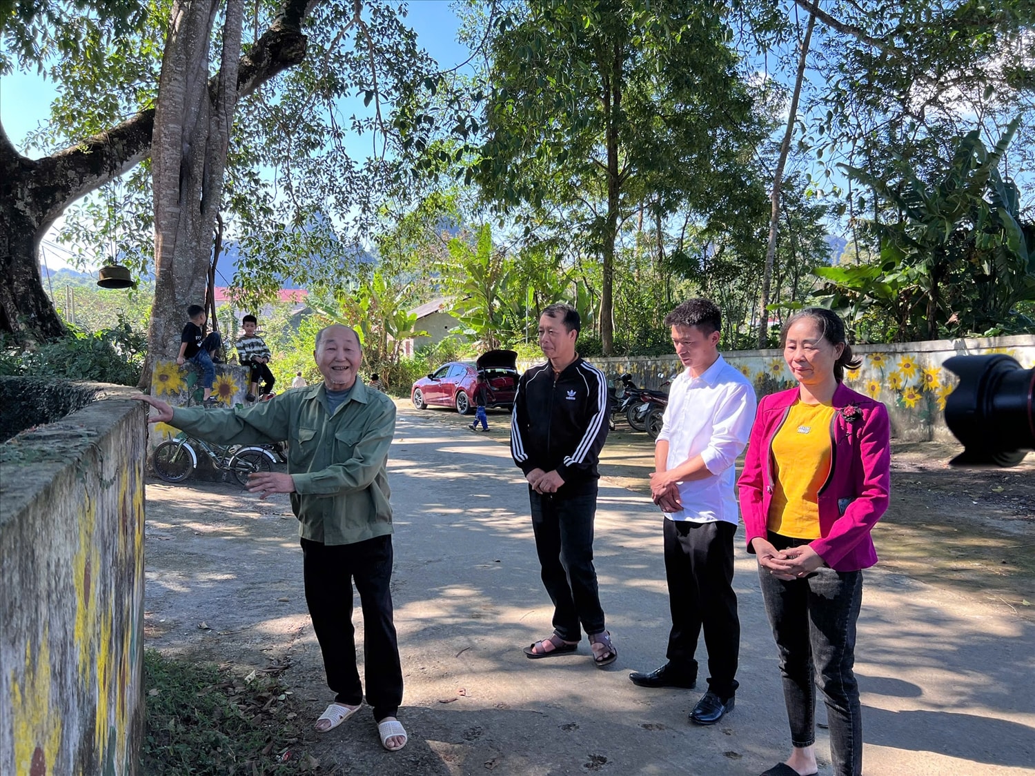 Người có uy tín Triệu Văn Khay (bên trái) trao đổi với người dân trong thôn về làm đường  Nông thôn mới