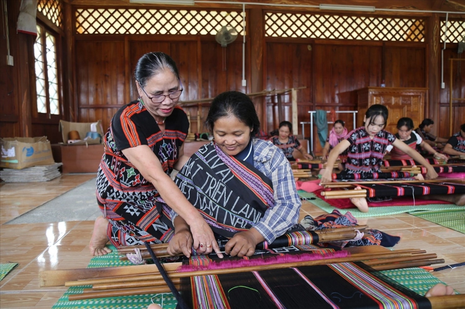 Nghệ nhân Mai Thị Hợp hướng dẫn các thành viên dệt Zèng.