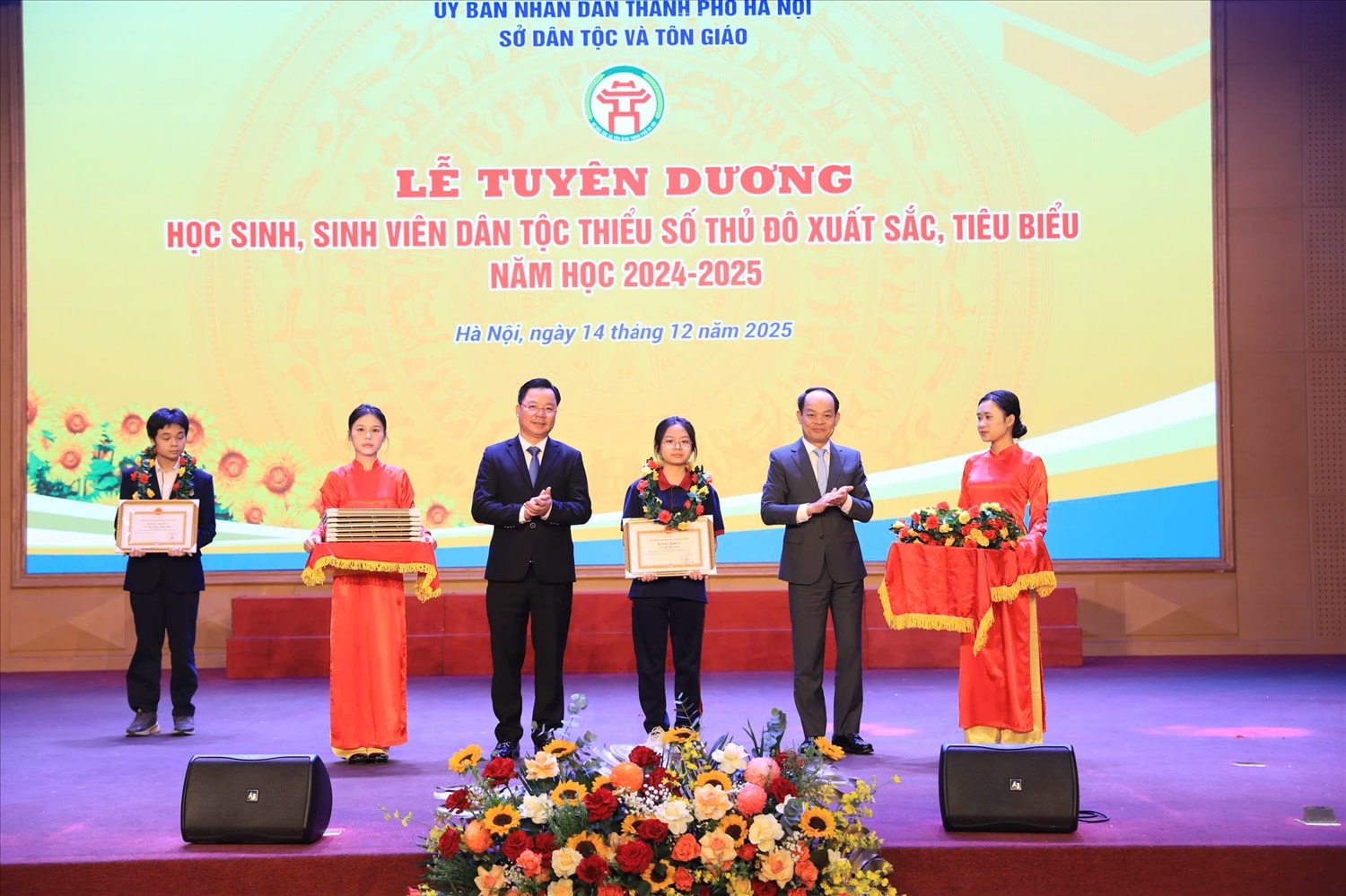 Ông Đinh Văn Khóa, Phó Trưởng Ban Tuyên giáo và Dân vận Thành ủy (đứng bên phải) và ông Nguyễn Sỹ Trường, Giám đốc Sở Dân tộc và Tôn giáo Thành phố Hà Nội (bên trái) tặng Bằng khen cho các em học sinh, sinh viên DTTS đạt giải cao trong Kỳ thi học sinh giỏi cấp quốc gia năm học 2024 - 2025.