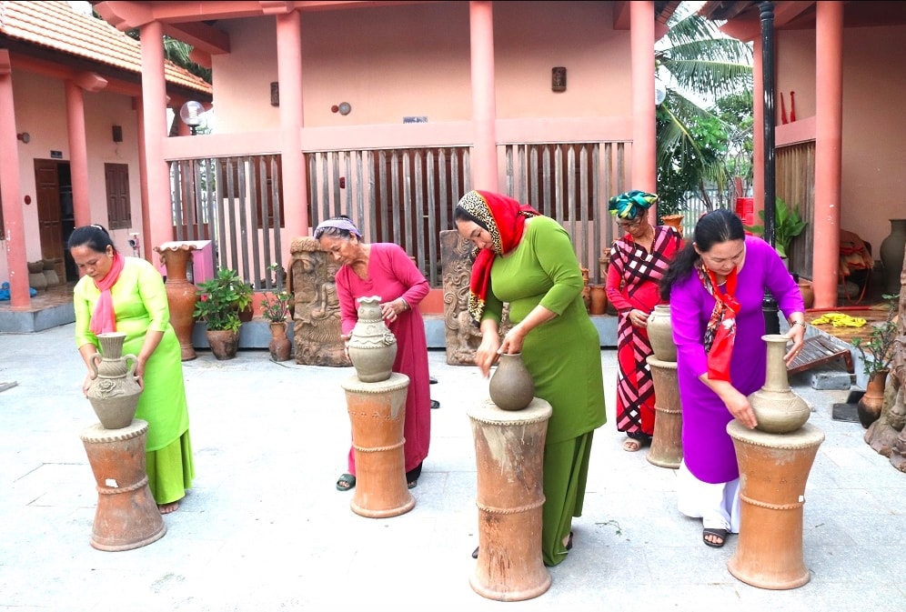 Nghệ nhân truyền dạy cách làm gốm truyền thống cho các học viên người Chăm. (Ảnh:X.H)