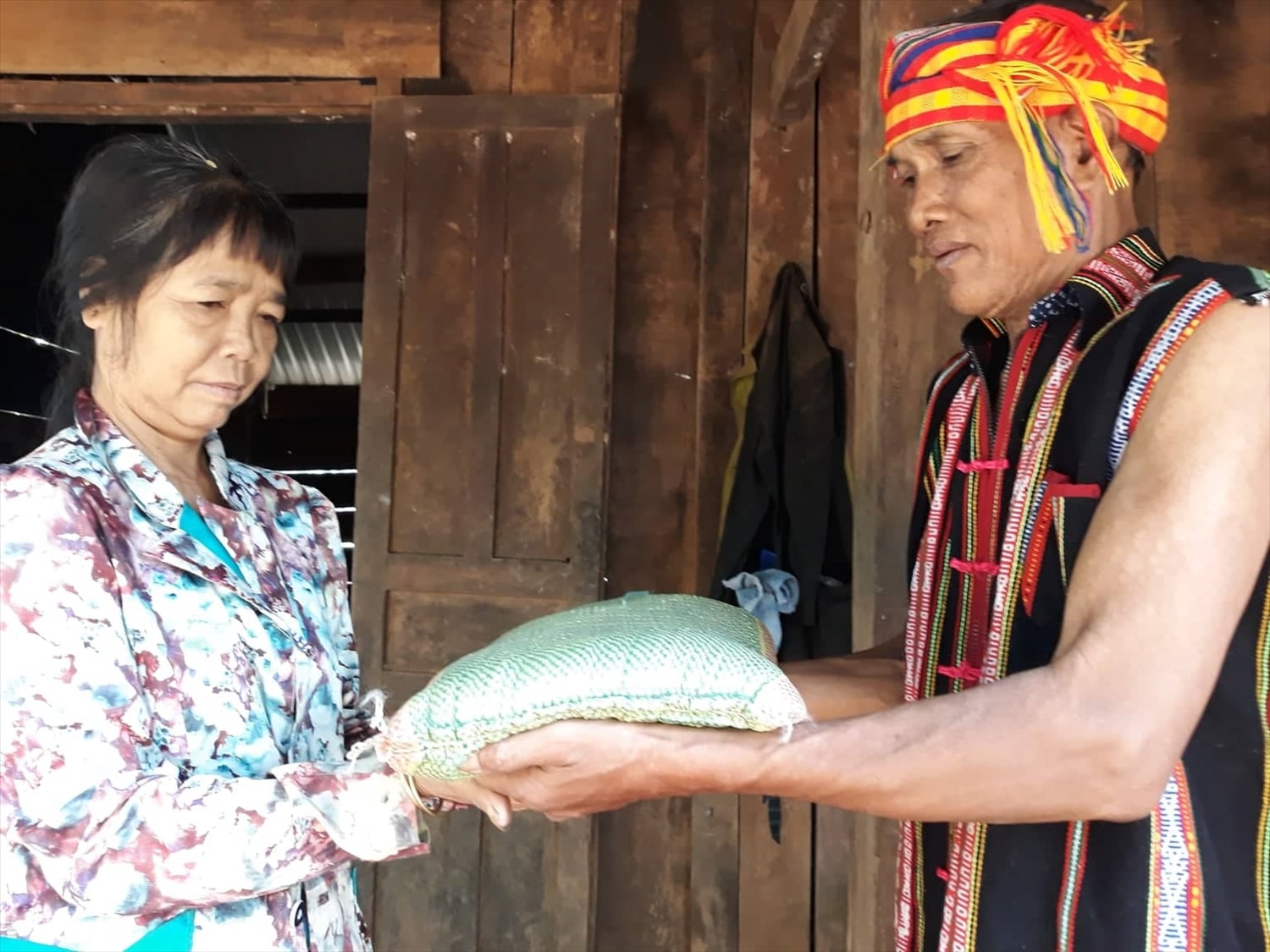 Ông Điểu Va, dân tộc Xtiêng, Người có uy tín thôn 2, xã Phước Sơn, tỉnh Đồng Nai (trước đây thuộc xã Thống Nhất, huyện Bù Đăng, tỉnh Bình Phước) trao gạo hỗ trợ hộ dân khó khăn trong sóc.