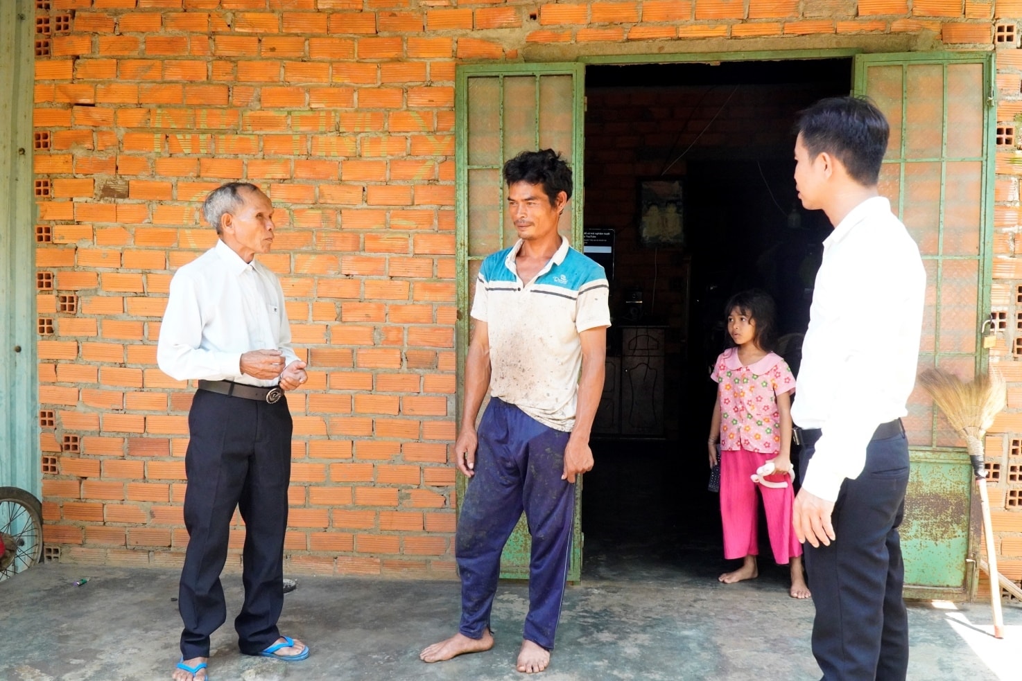 Già làng Điểu Cu (bên trái, 75 tuổi), đồng bào Xtiêng, thôn Phu Mang 1, xã Long Hà, tỉnh Đồng Nai thăm hỏi bà con trong làng.
