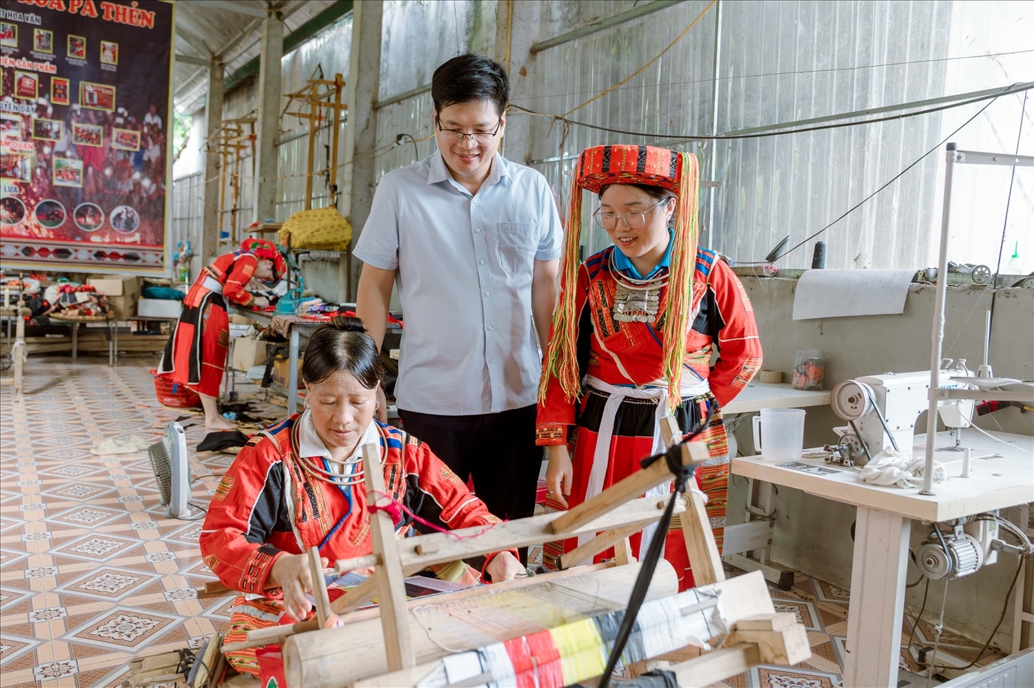 Chị Tải Thị Mai, Giám đốc HTX Dệt thổ cẩm Pà Thẻn thôn My Bắc, xã Tân Trịnh (bên phải bức ảnh) giới thiệu về các công đoạn dệt thủ công truyền thống của đồng bào dân tộc Pà Thẻn