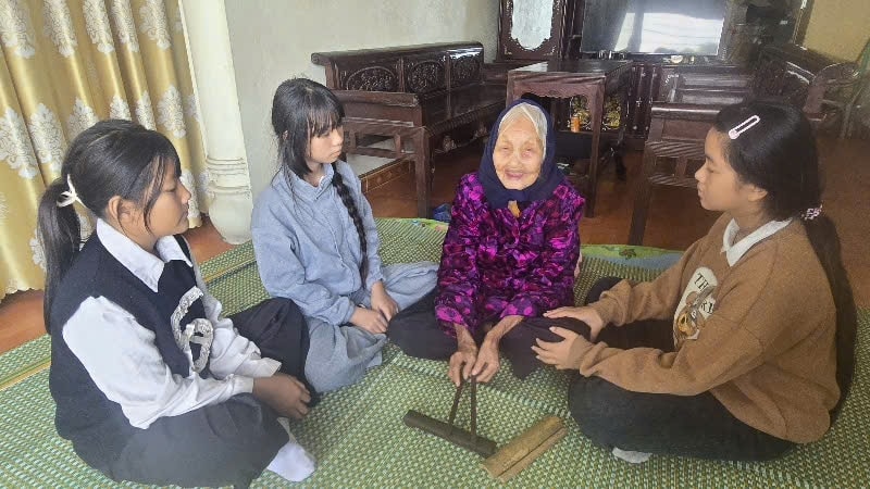 Nghệ nhân Đặng Thị Tự đang truyền dạy hát nhà tơ cho thế hệ trẻ. Ảnh: Mỹ Dung