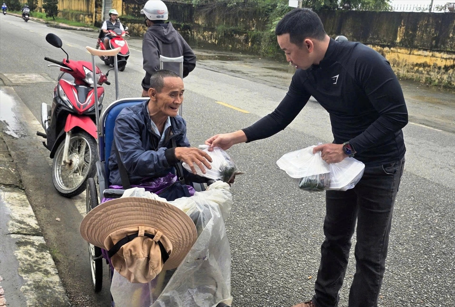 Thiếu tá Trương Văn Tài trao suất cơm cho một cụ ông có hoàn cảnh khó khăn. (Ảnh: Đ.Quang)