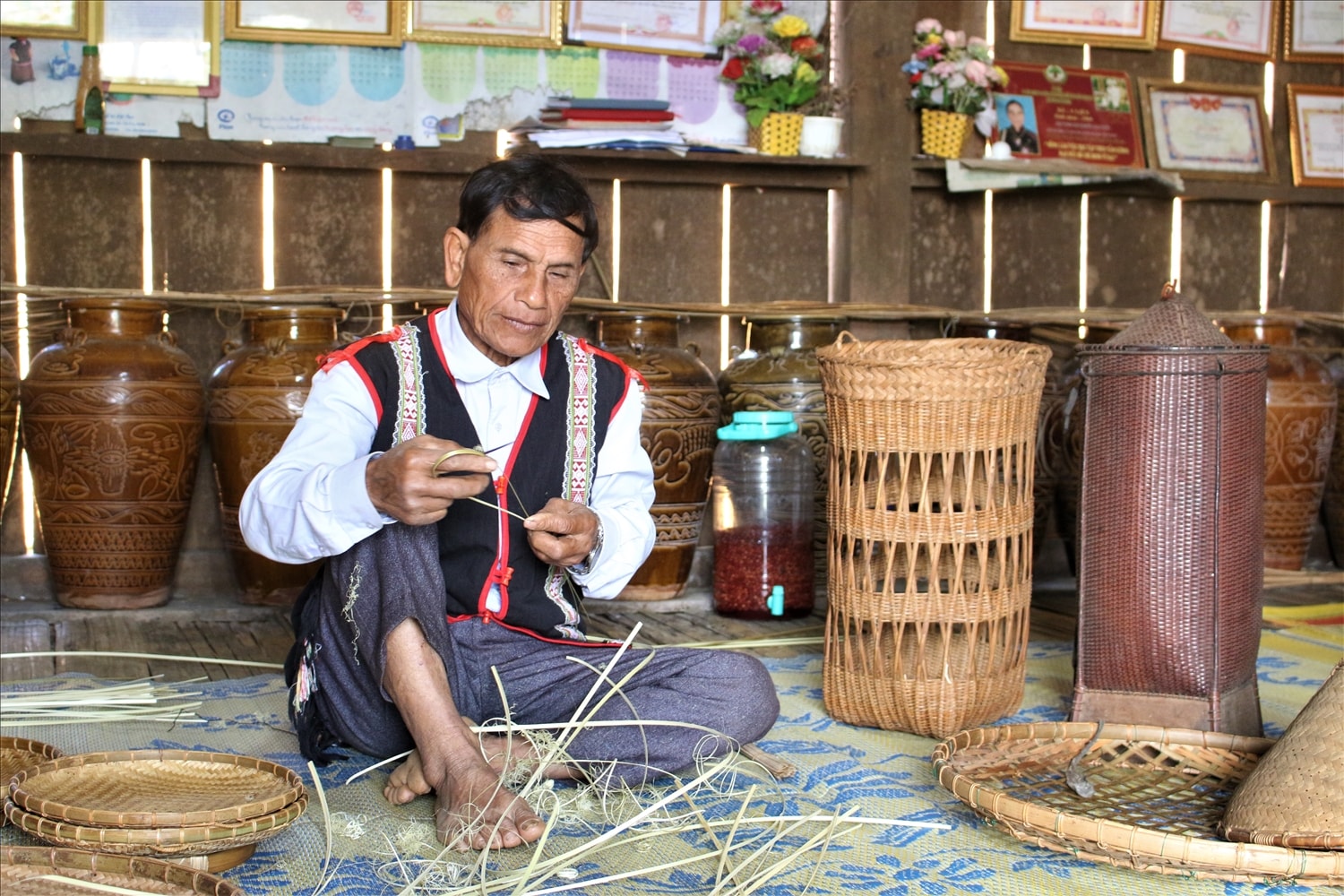 Nghệ nhân Ưu tú A Lễ vẫn đang miệt mài giữ nghề đan lát truyền thống của người Xơ Đăng – nhánh Mơ Nâm. (Ảnh: Ngọc Chí)