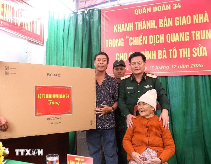 Thiếu tướng Nguyễn Trần Long, Phó Chính ủy Quân đoàn 34, trao tặng quà cho hộ gia đình bà Tô Thị Sửa, 88 tuổi, thôn Chánh Hội, xã Phù Mỹ, tỉnh Gia Lai. (Ảnh: TTXVN)