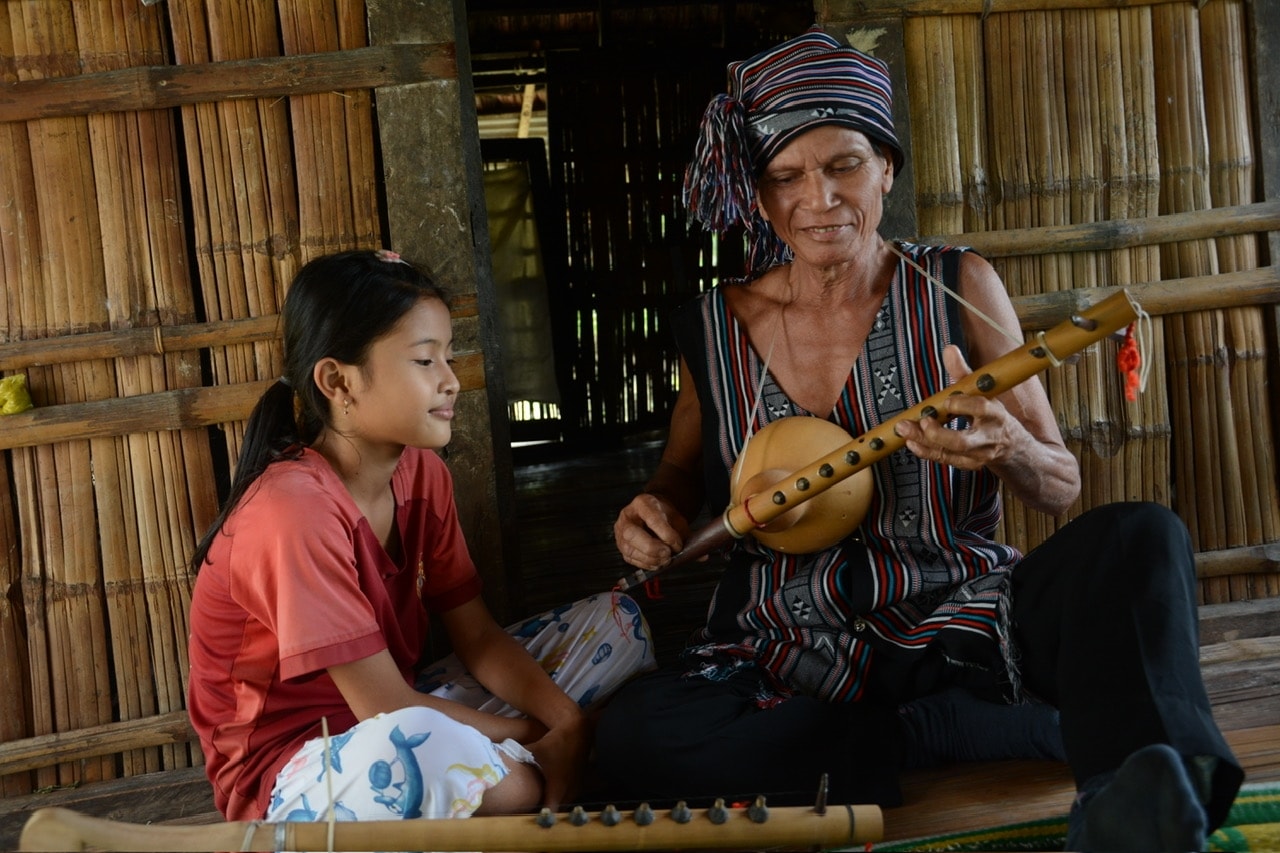 Nghệ nhân Ưu tú xã Sơn Thủy (Quảng Ngãi) giới thiệu, giải thích về nhạc cụ dân tộc cho người cháu.