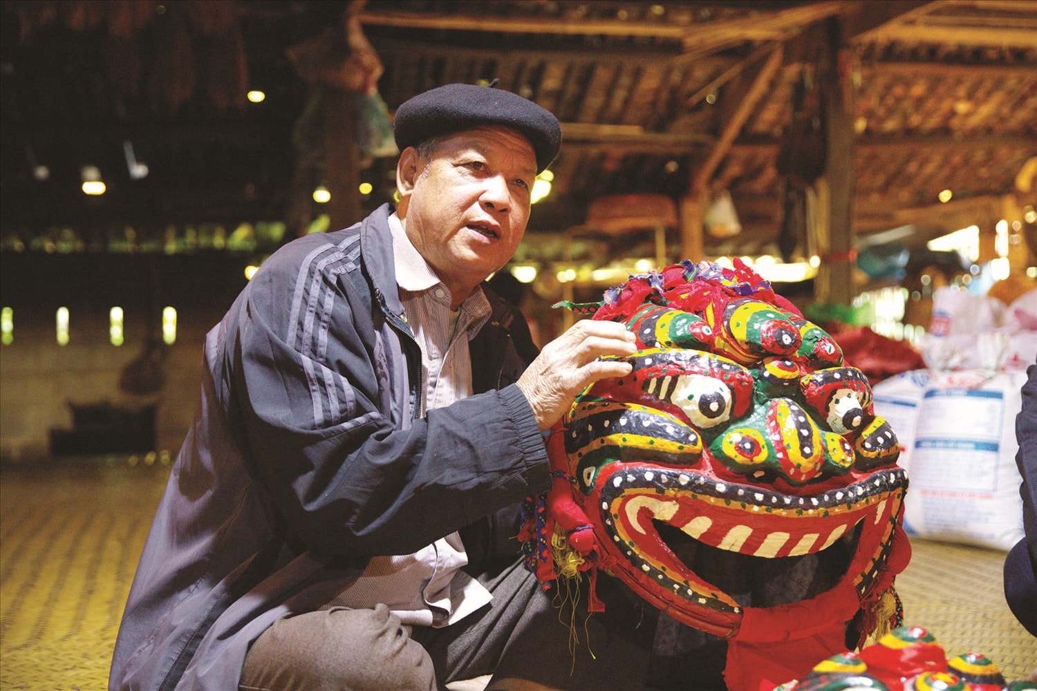 Ông Lâm Văn Đầm bên mặt nạ sư tử mèo