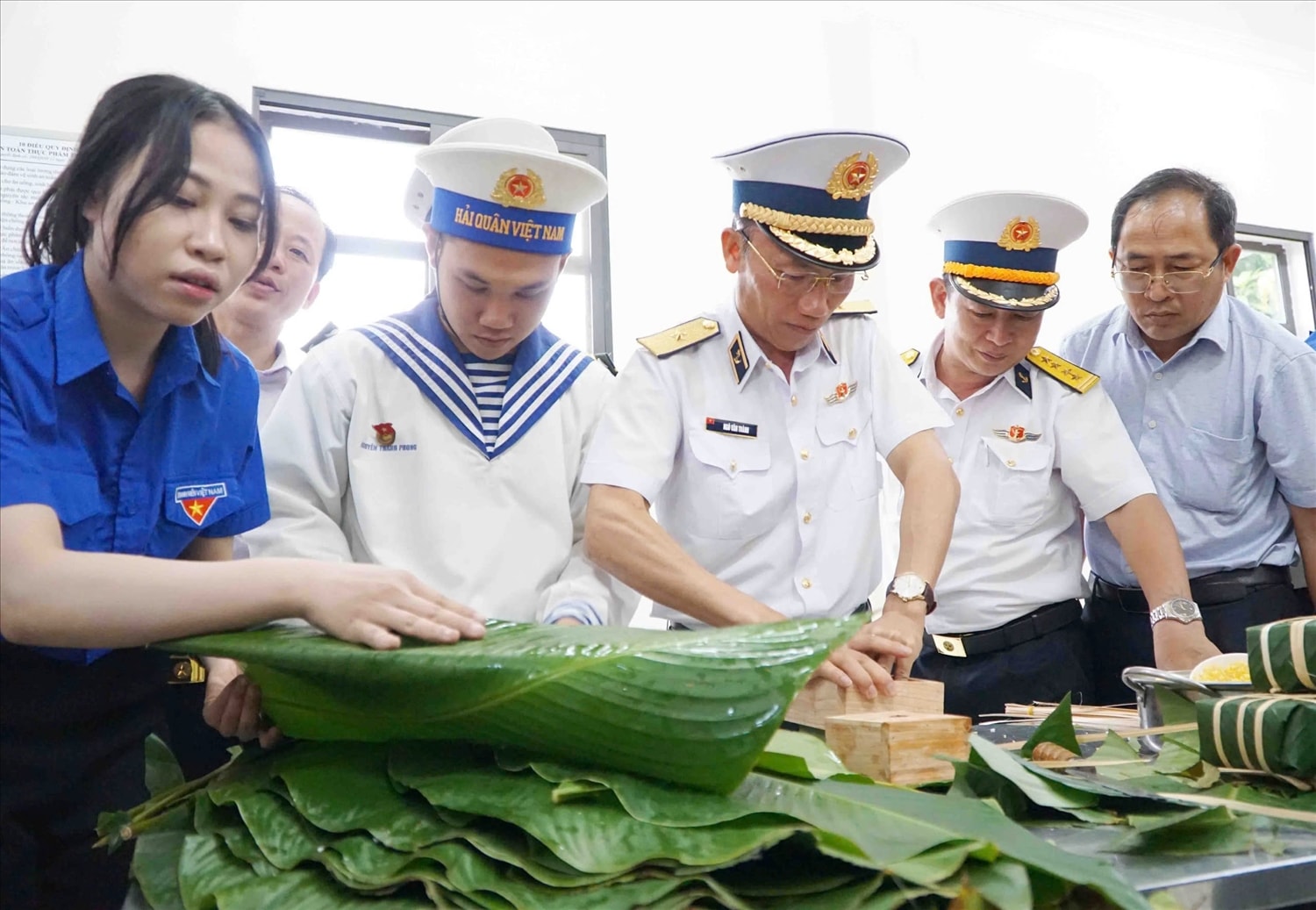 Chuẩn Đô đốc Ngô Văn Thành ( đứng giữa), Chính ủy Vùng 5 Hải quân, Trưởng đoàn công tác tham gia gói bánh chưng cùng sĩ  và đại biểu đoàn công tác