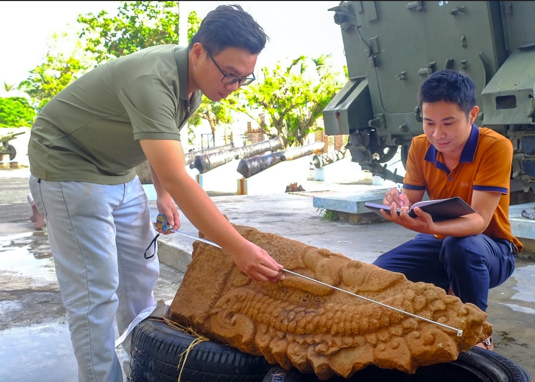 Cán bộ Bảo tàng tỉnh Gia Lai đo đạc lại hiện vật vừa phát hiện ở tháp Dương Long để đưa vào bảo quản. (Ảnh N.N)