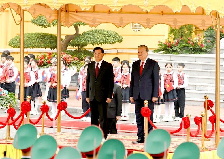 Tổng Bí thư Tô Lâm và Tổng Bí thư, Chủ tịch nước Lào Thongloun Sisoulith trên bục danh dự, thực hiện nghi thức chào cờ - Ảnh: VGP/Nhật Bắc