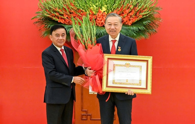 Thường trực Ban Bí thư Trần Cẩm Tú trao huy hiệu 45 năm tuổi đảng, tặng hoa chúc mừng đồng chí Tô Lâm, Tổng Bí thư Ban Chấp hành Trung ương Đảng Cộng sản Việt Nam. (Ảnh: DUY LINH)