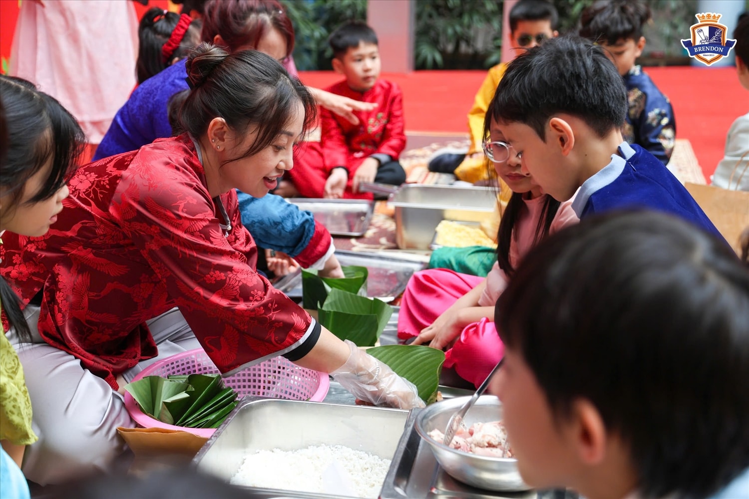 Hoạt động gói bánh chưng của các em học sinh dưới sự hướng dẫn của thầy cô và các bậc phụ huynh