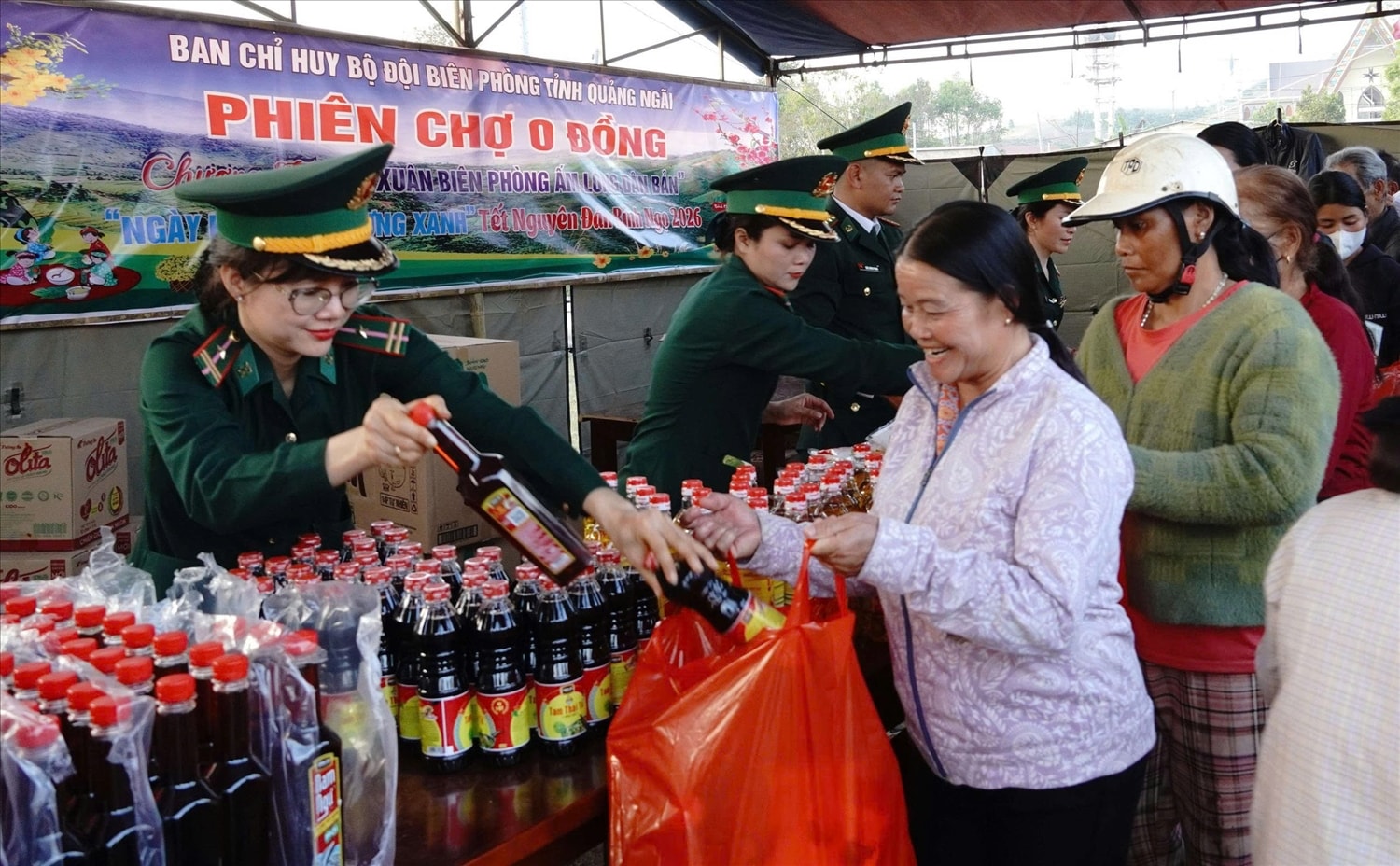 Nhân dân xã biên giới Sa Loong nhận các nhu yếu phẩm từ gian hàng không đồng. (Ảnh: Ngọc Chí)