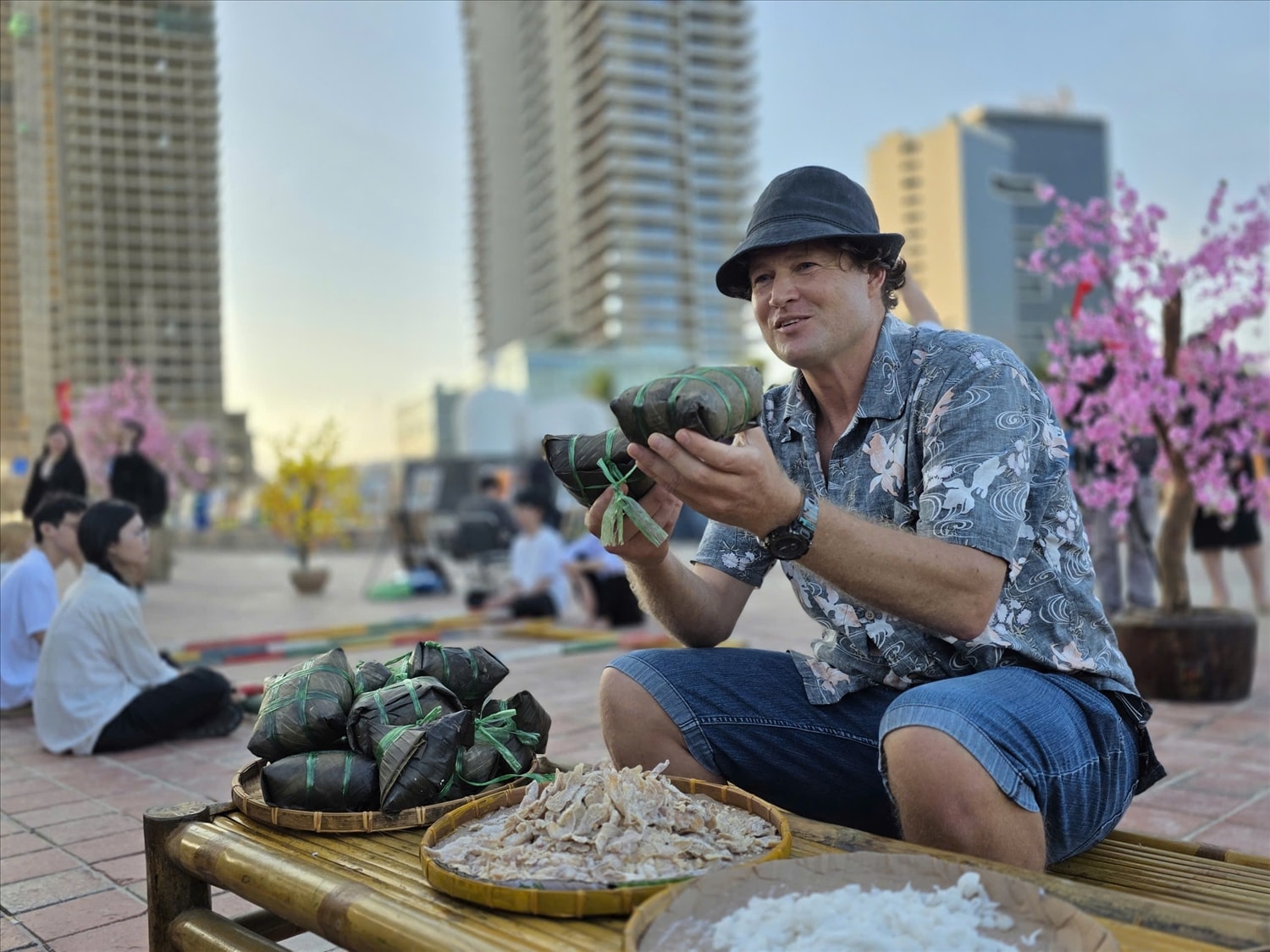 Một du khách nước ngoài thích thú trải nghiệm khu ẩm thực Tết ở bãi biển Đà Nẵng. (Ảnh CN)