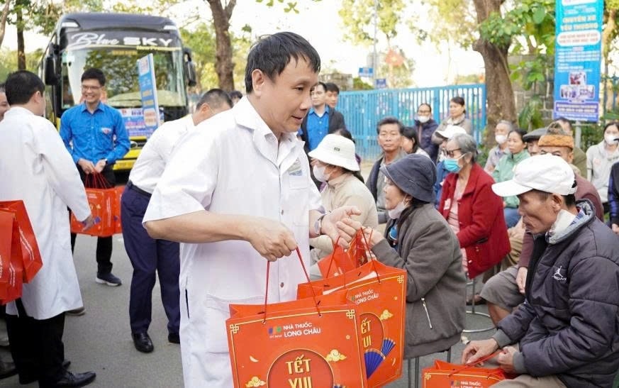 Lãnh đạo Bệnh viện Trung ương Huế trao quà cho bệnh nhân trước lúc lên xe về quê đón Tết (Ảnh: Quang Điền)