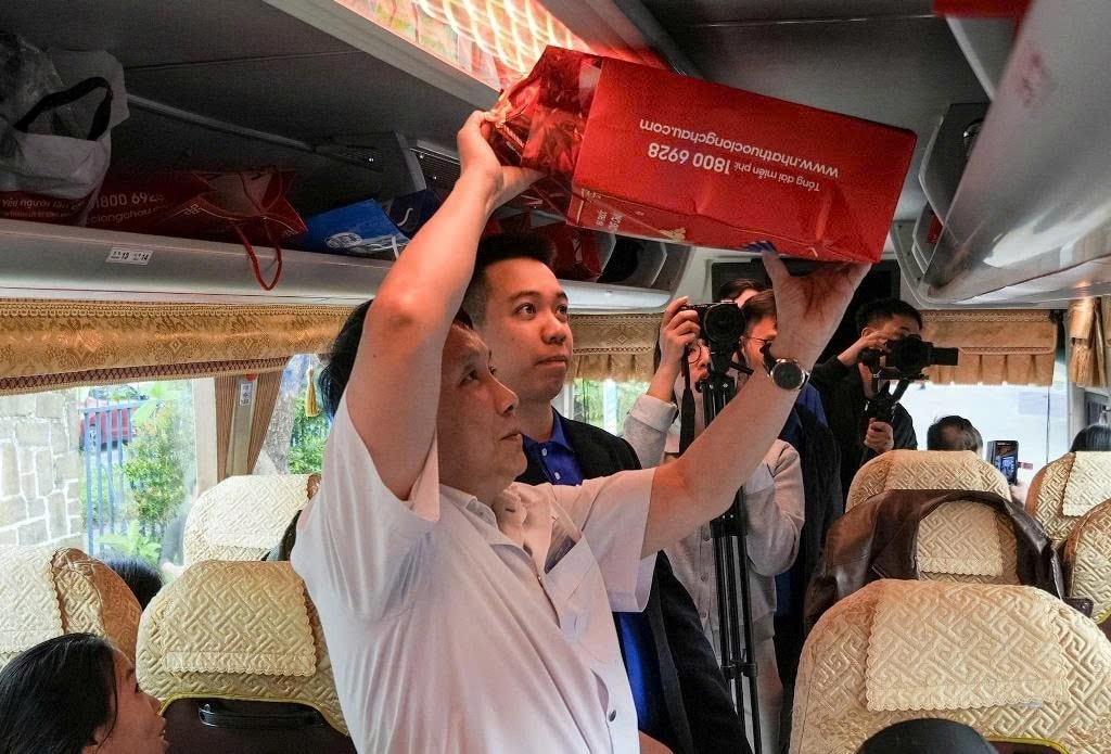 GS.TS Phạm Như Hiệp, Giám đốc Bệnh viện Trung ương Huế (Áo trắng) trực tiếp lên xe động viên và sắp xếp hành lý cho bệnh nhân (Ảnh: Điền Quang)