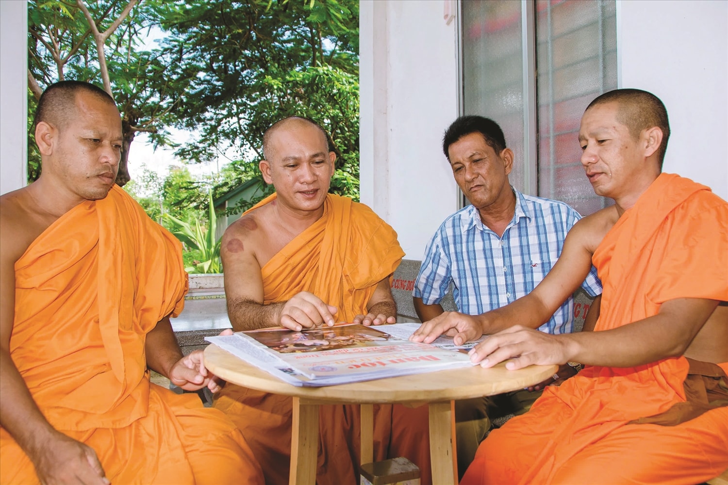 Đại đức Chau Bện cùng Ban Quản trị chùa chọn thông tin trên ấn phẩm Dân tộc và Phát triển để tuyên truyền, vận động đồng bào DTTS