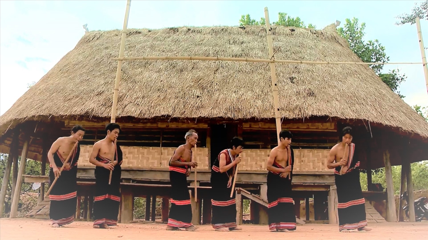 Người biễu diễn tay trái cầm đinh tút, tay phải ép sát vào ngực, tạo nên tư thế của thân hình nghiêng xuống với mặt đất và lắc lư theo nhịp. (Ảnh: Ngọc Chí)