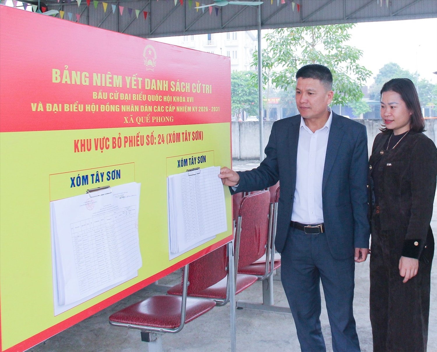 Cán bộ xã Quế Phong kiểm tra việc niêm yết danh sách cử tri tại khu dân cư - Ảnh: M.H