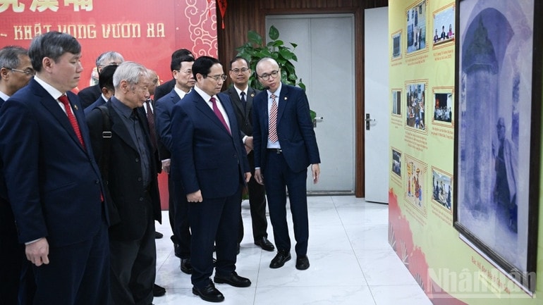 Thủ tướng Phạm Minh Chính nghe giới thiệu về quá trình phát triển của Viện Hàn lâm Khoa học xã hội Việt Nam. (Ảnh: TRẦN HẢI)