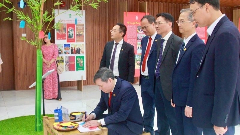 Giáo sư, Tiến sĩ Lê Văn Lợi, Chủ tịch Viện Hàn lâm Khoa học xã hội Việt Nam viết lời chúc năm mới tại không gian trưng bày cây Nêu – biểu tượng truyền thống của dân tộc Việt Nam về một năm mới an lành. Ảnh ITN