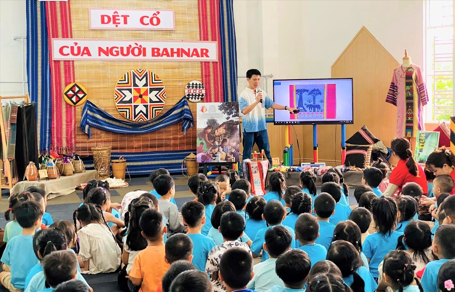 Anh Huỳnh Nguyên Thông giới thiệu về nghề dệt thổ cẩm của người Ba Na cho các cháu học sinh