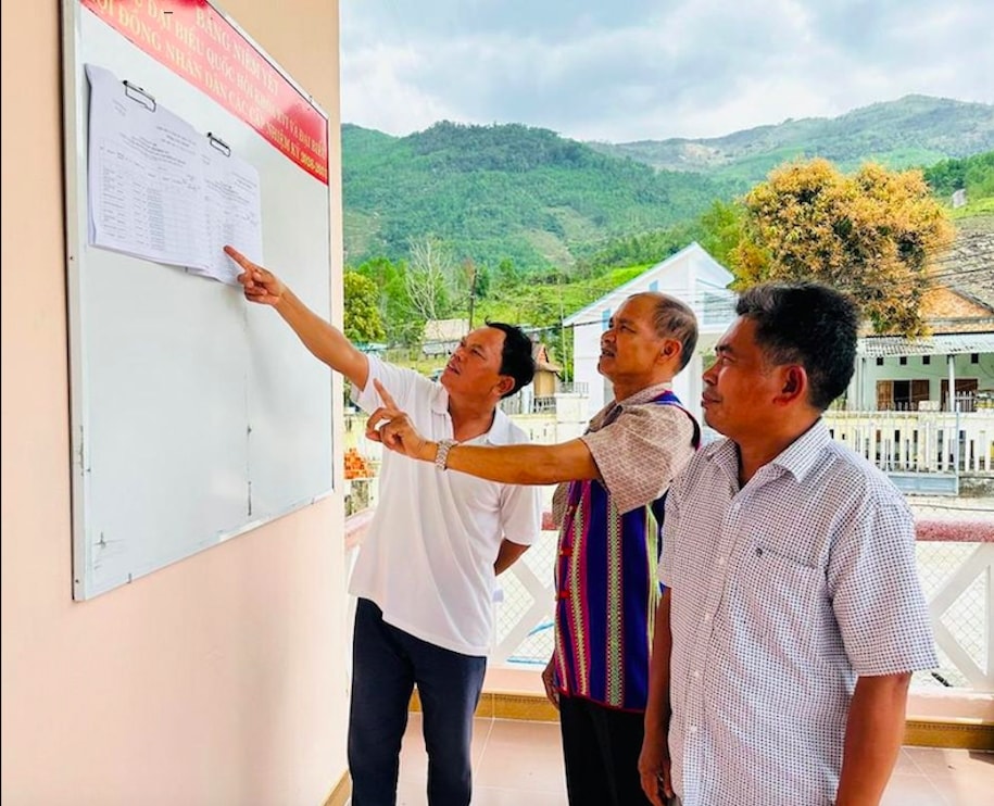Ông Trần Văn Lũ (ở giữa) tuyên truyền giúp người dân thường xuyên cập nhật thông tin tiểu sử, quá trình công tác của các ứng cử viên ĐBQH và đại biểu HĐND các cấp. (Ảnh: D.Đ)