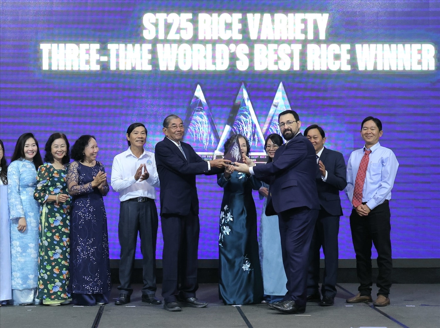Tổ chức The Rice Trader trao Cup Gạo ngon nhất thế giới năm 2025 cho gạo Ông Cua ST25 của Việt Nam, vinh danh Anh hùng Lao động Hồ Quang Cua (người cầm cúp bên trái) cùng nhóm tác giả. Đây là lần thứ ba gạo ST25 được vinh danh quốc tế là gạo ngon nhất thế giới. (Ảnh: Trung Phạm)
