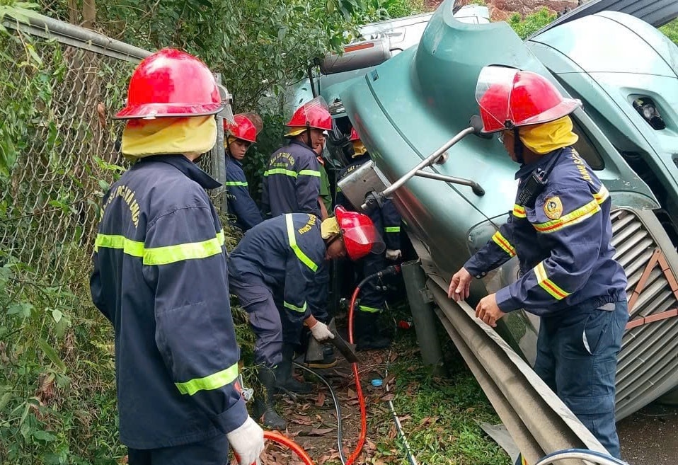 Lực lượng chức năng kịp thời giải cứu tài xế bị mắc kẹt. (Ảnh Công an cung cấp)